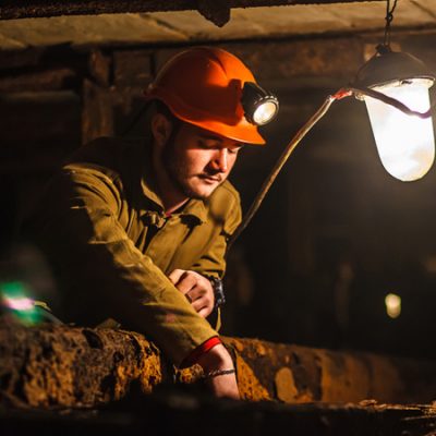 Hombre Joven Revisando Una Instalación Con Un Casco Con Linterna