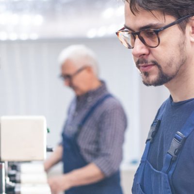 Hombre Joven Trabajando En Primer Plano Y Persona Mayor En Segundo