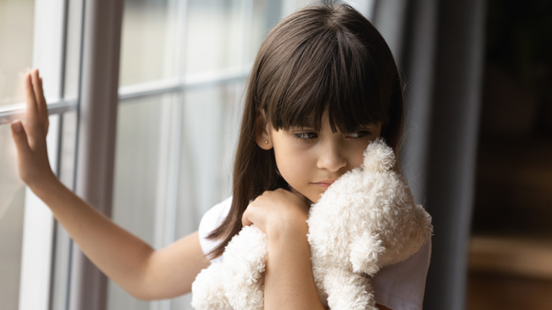 niña agustiada con un oso de peluche en la mano