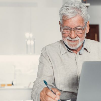 Persona De Tercera Edad Trabajando Enfrente A Una Pc